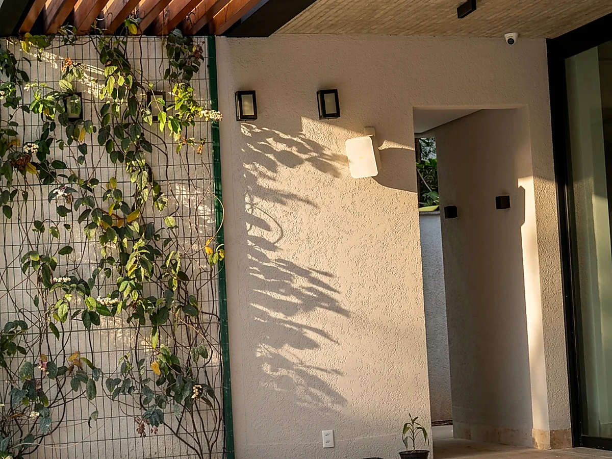 Acesso lateral com muro verde e forro de madeira em casa residencial entregue pela HC Engenharia
