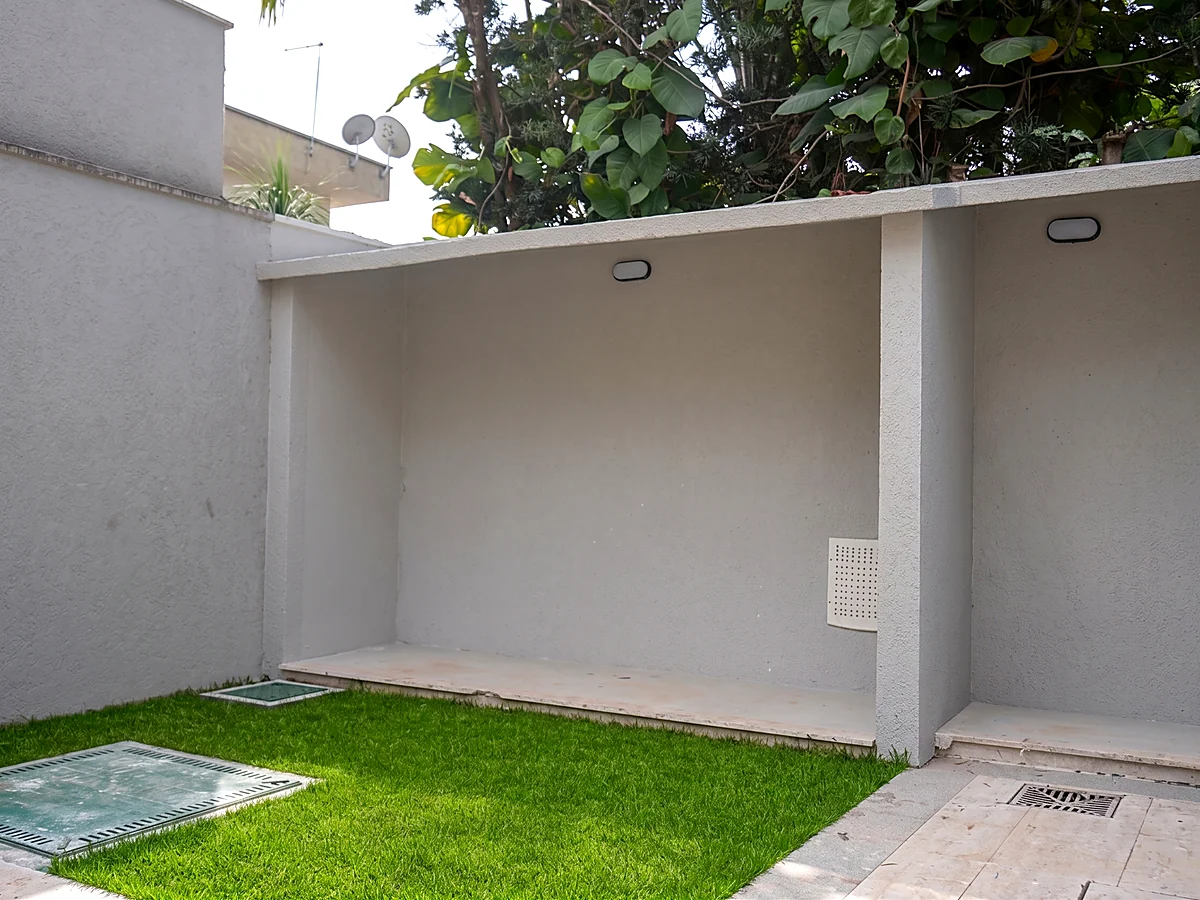 Área coberta e gramado na lateral de casa residencial entregue pela HC Engenharia