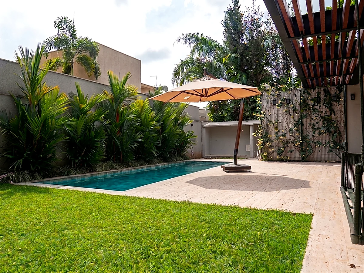 Piscina em raia com jardim e paisagismo de casa residencial entregue pela HC Engenharia