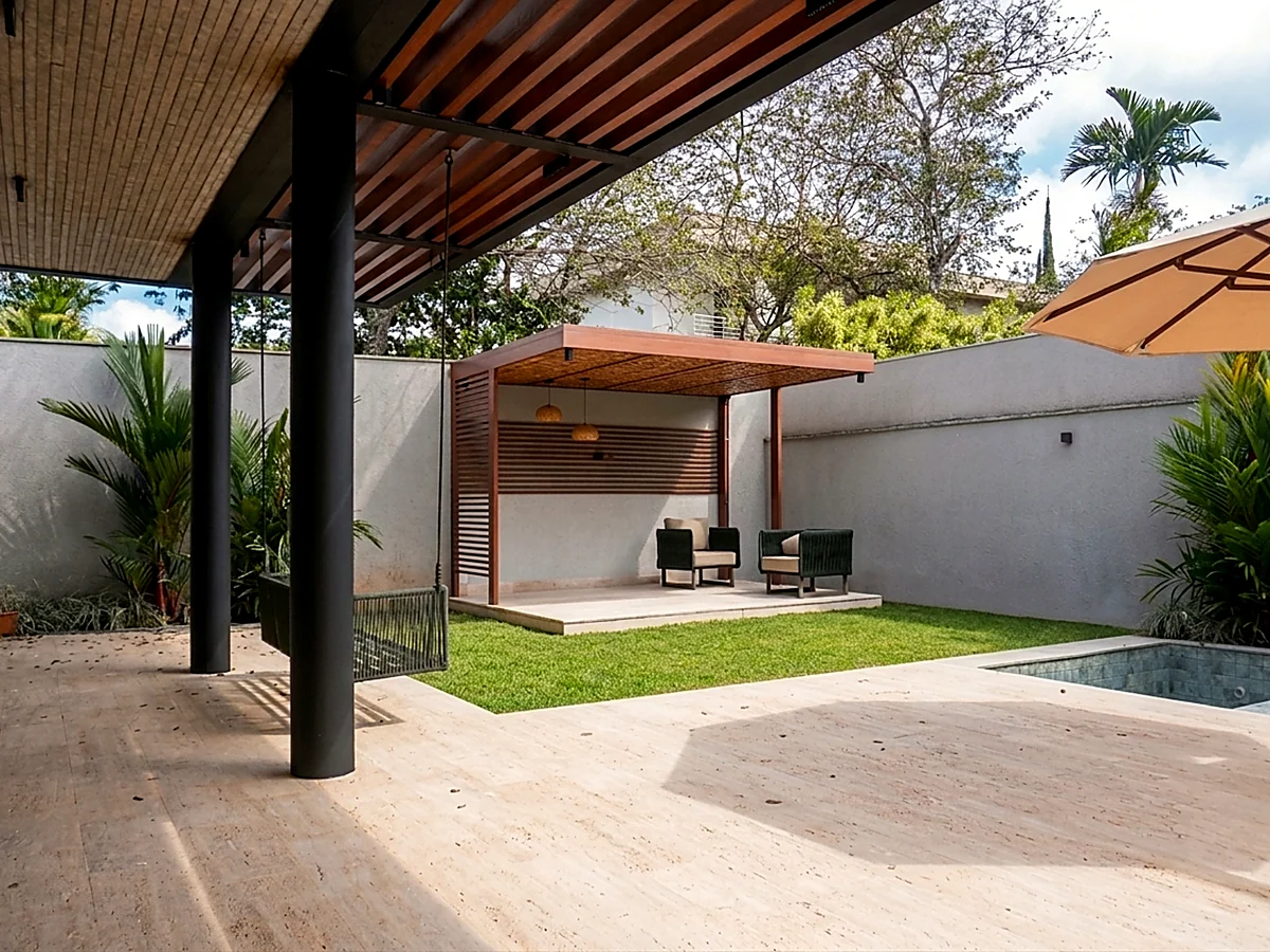 Varanda coberta com vista para o lounge e a piscina de casa residencial entregue pela HC Engenharia
